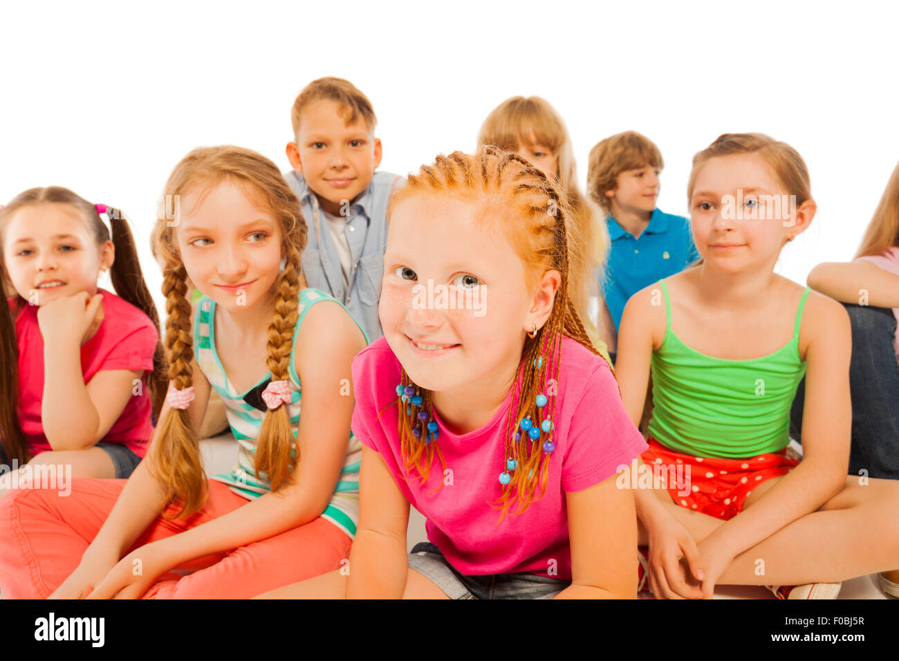 Two Happy Little Girls Sit In Group Of Friends Stock Photo Alamy