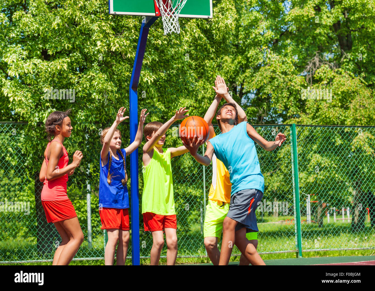 Group of happy teenagers playing basketball Stock Photo