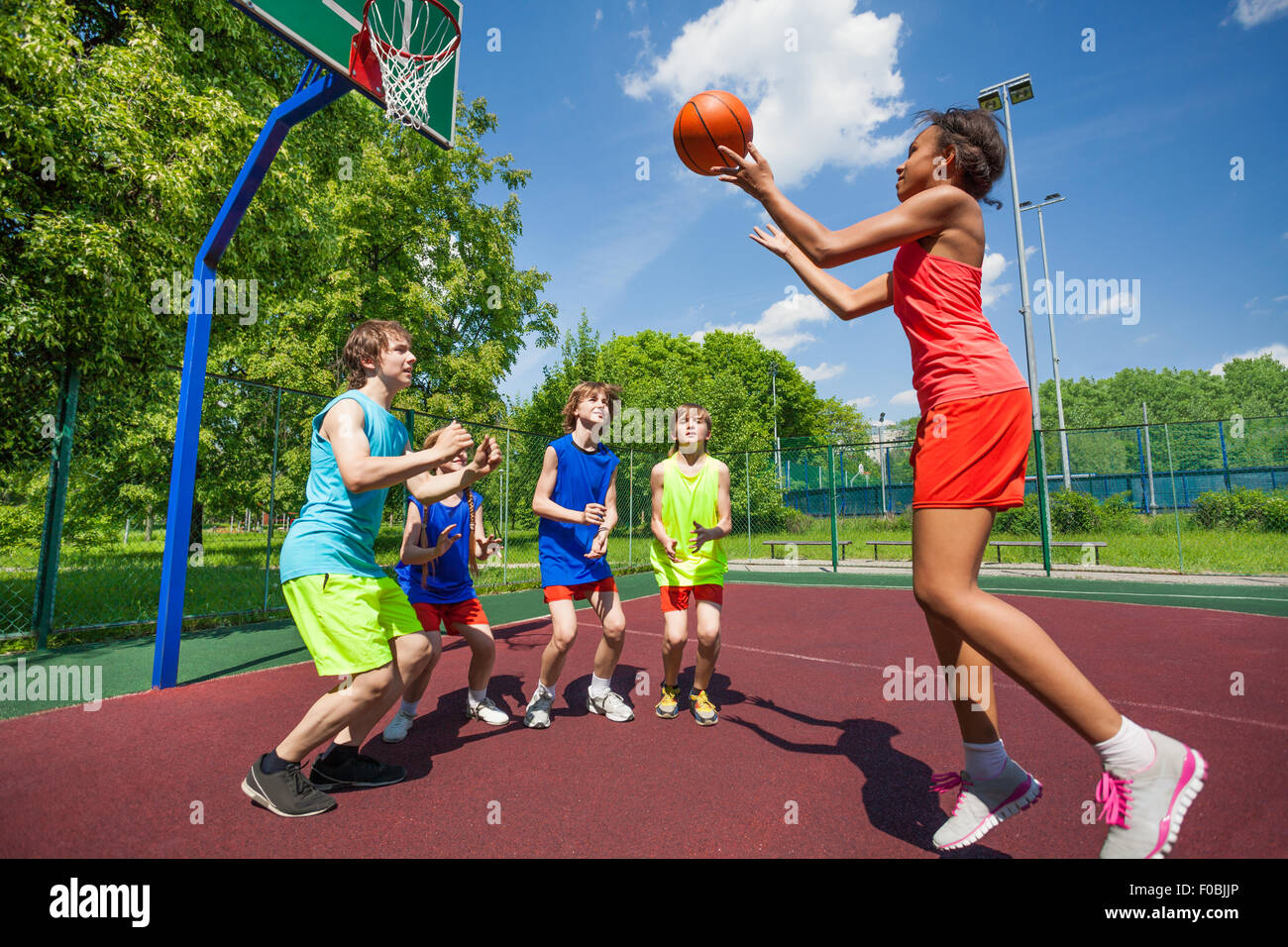 Teenagers are playing basketball game on ground Stock Photo