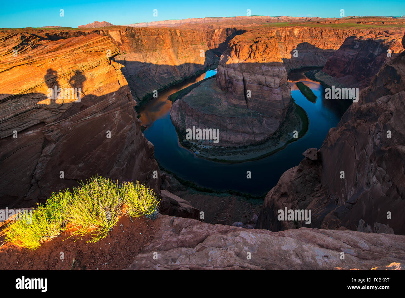 Shadows of couple taking pictures Horseshoe Bend Page Arizona at Sunrise Stock Photo