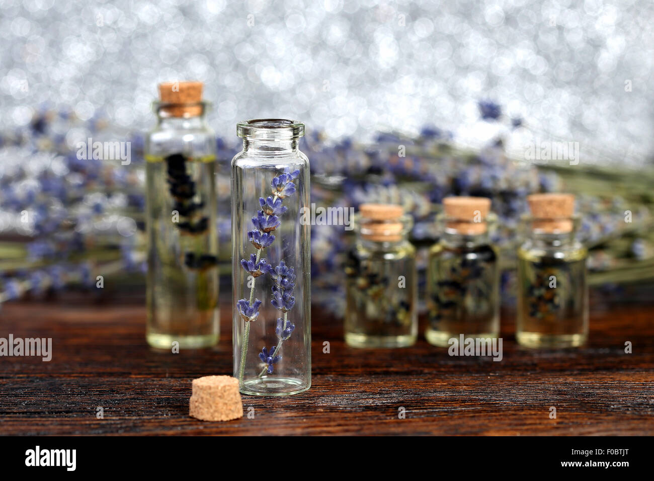 Lavender oil in a glass bottle on a wooden table Stock Photo