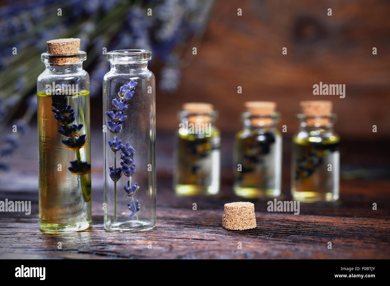 Lavender oil in a glass bottle on a wooden table Stock Photo