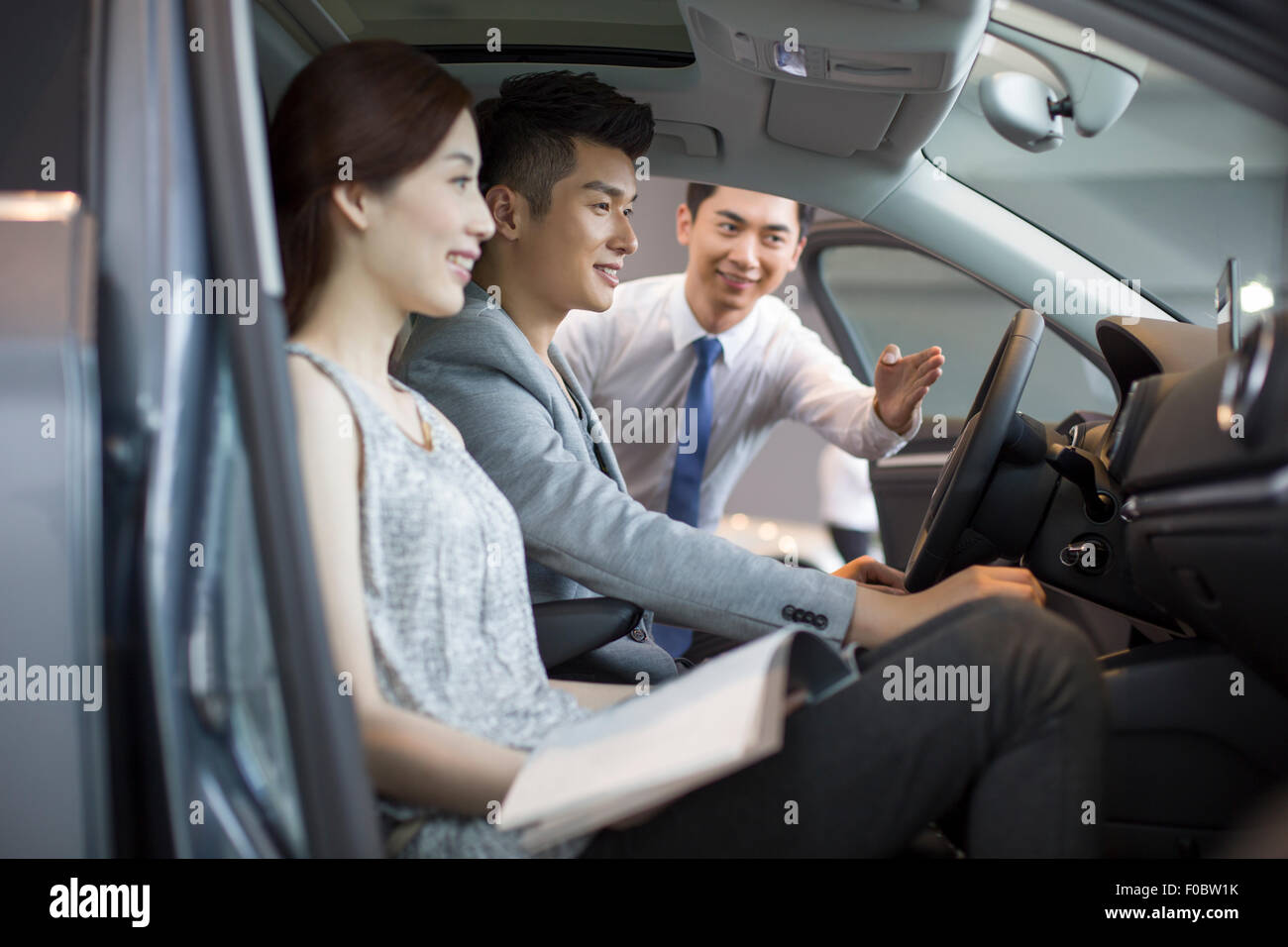 Young couple choosing car in showroom Stock Photo