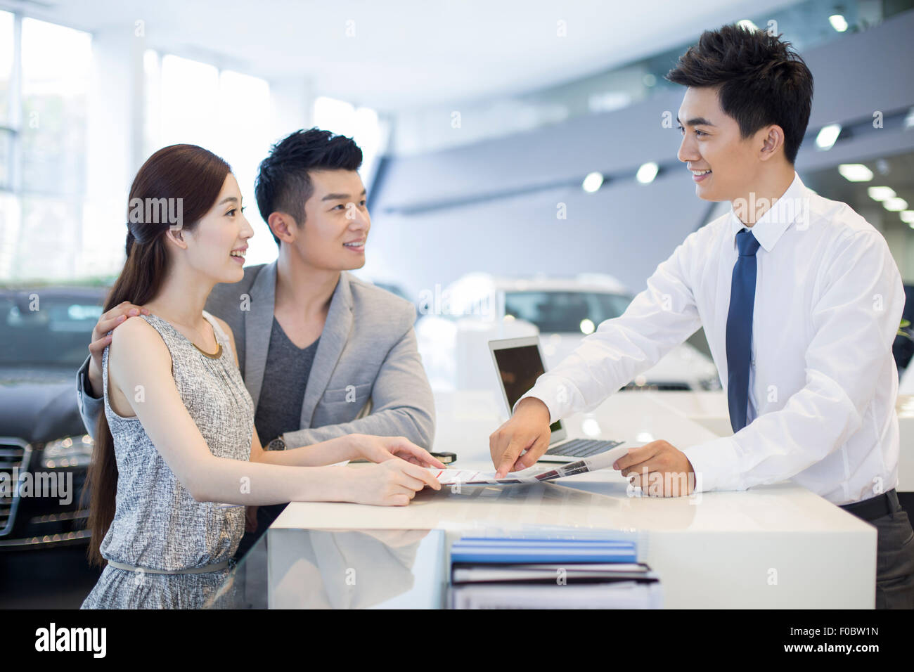 Young couple buying car in showroom Stock Photo