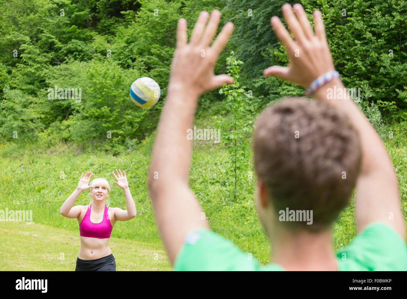 Young couple playing volleyball in park. Stock Photo