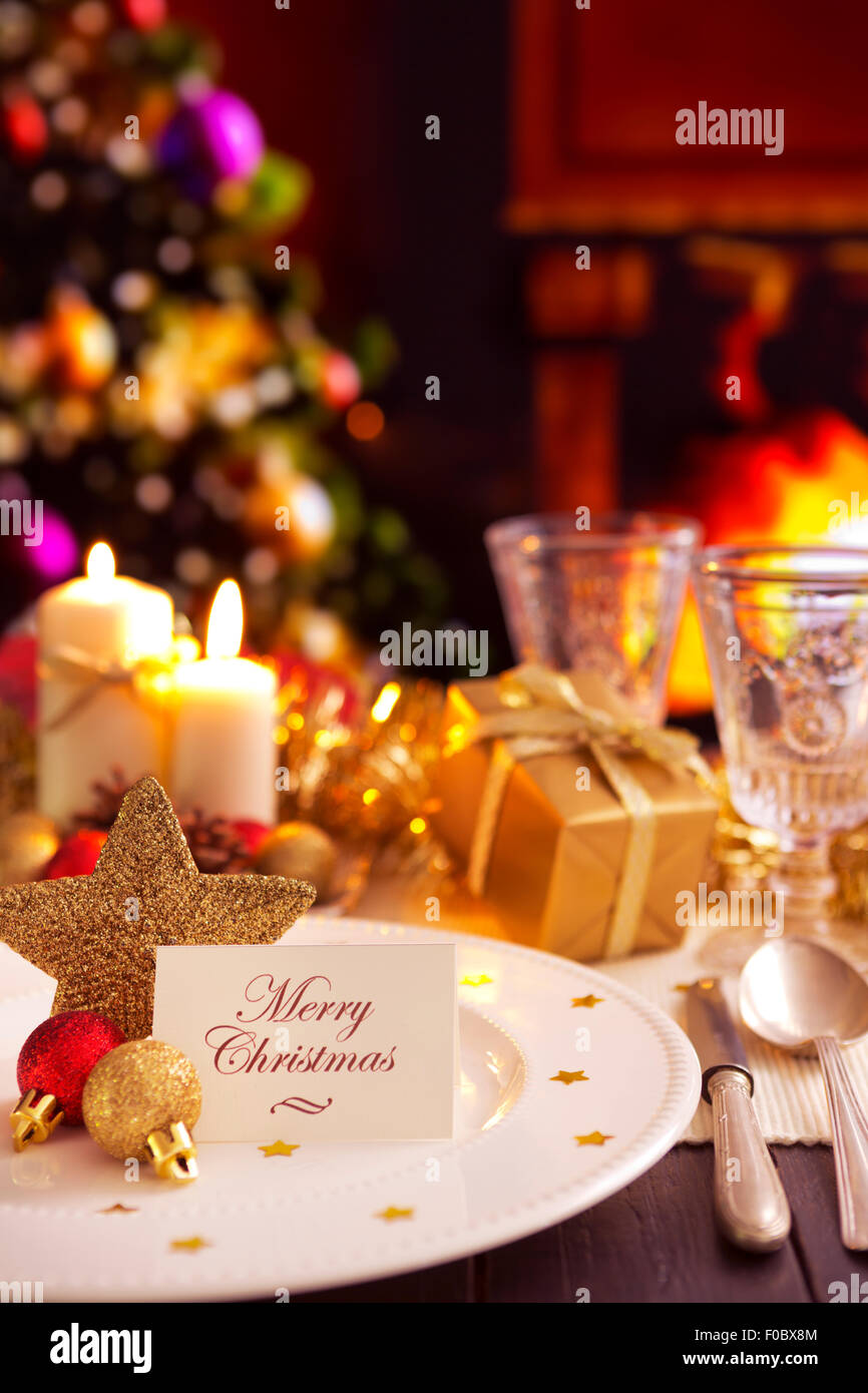 A romantic Christmas dinner table setting with candles and Christmas decorations. Stock Photo