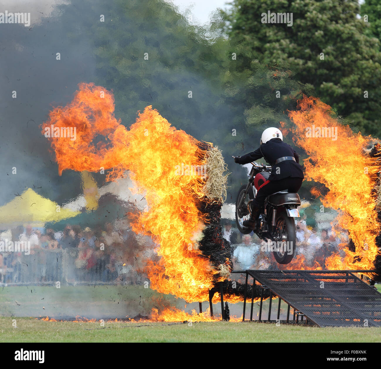 Royal Signals White Helmets Motor cycle Display Team driving through fire on a Motor bike at the Halifax show in August 2015 Stock Photo