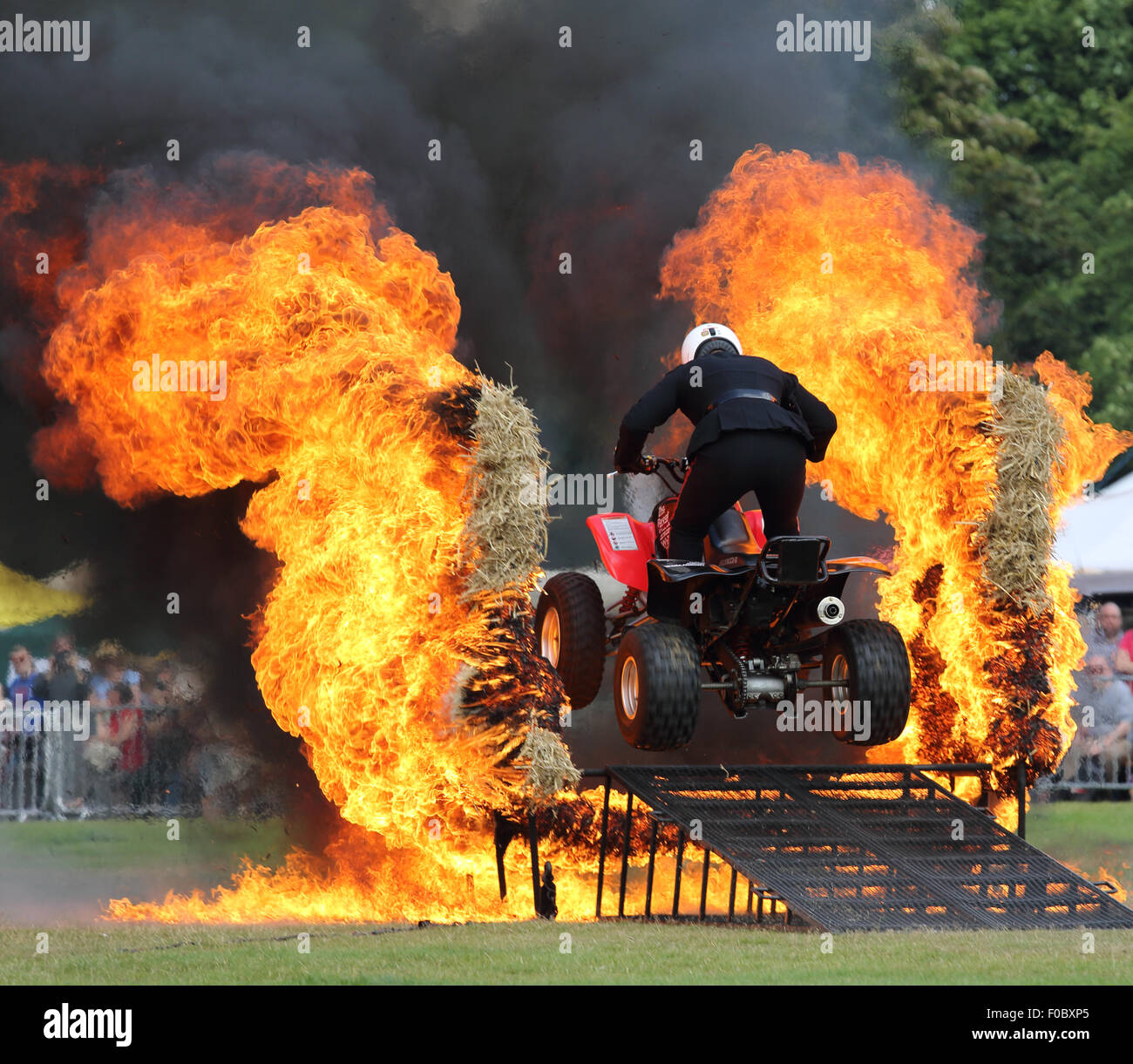 Royal Signals White Helmets Motor cycle Display Team driving through fire on a quad bike at the Halifax show in August 2015 Stock Photo