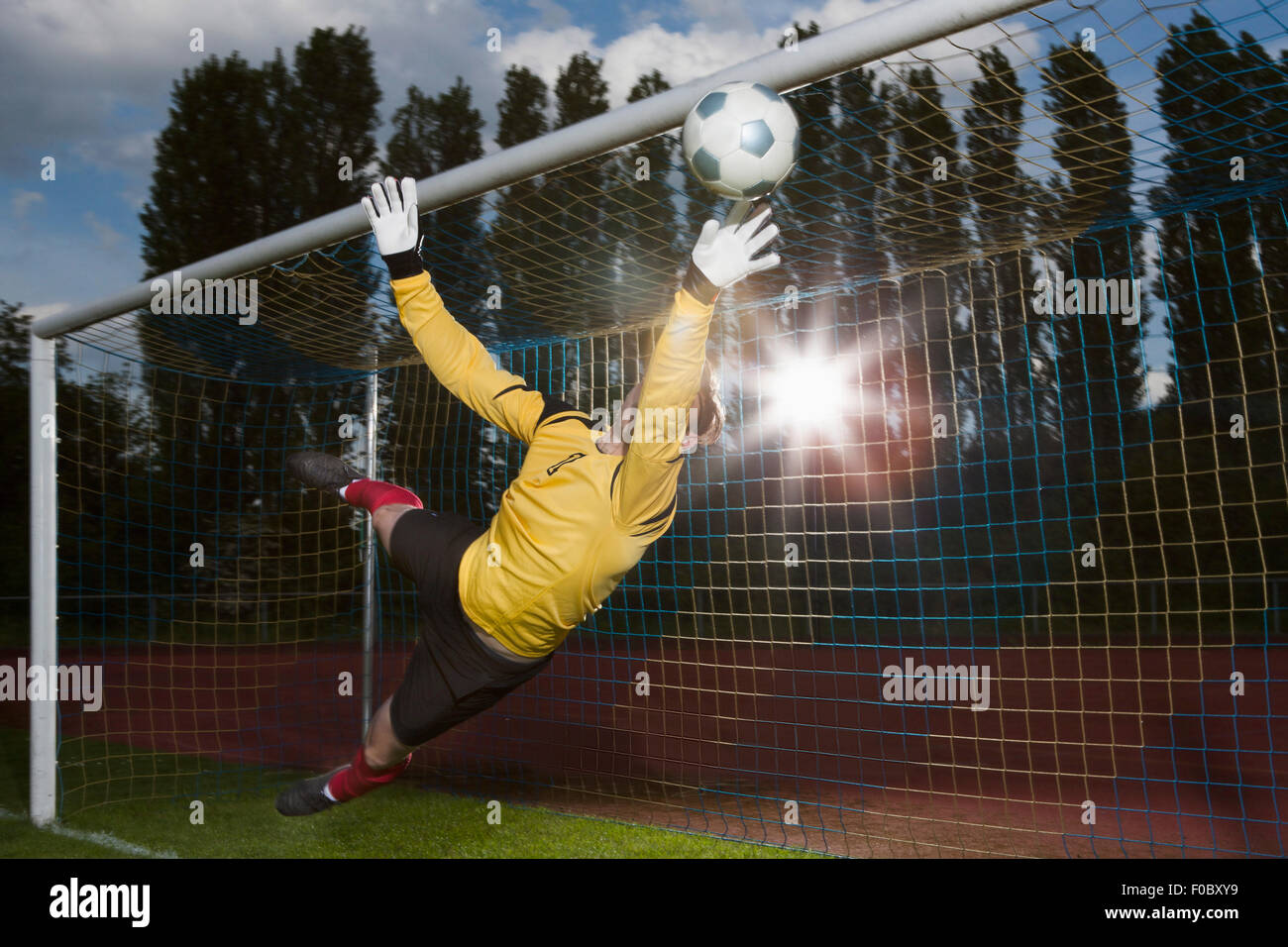 Full length of soccer goalkeeper diving to block ball Stock Photo Alamy