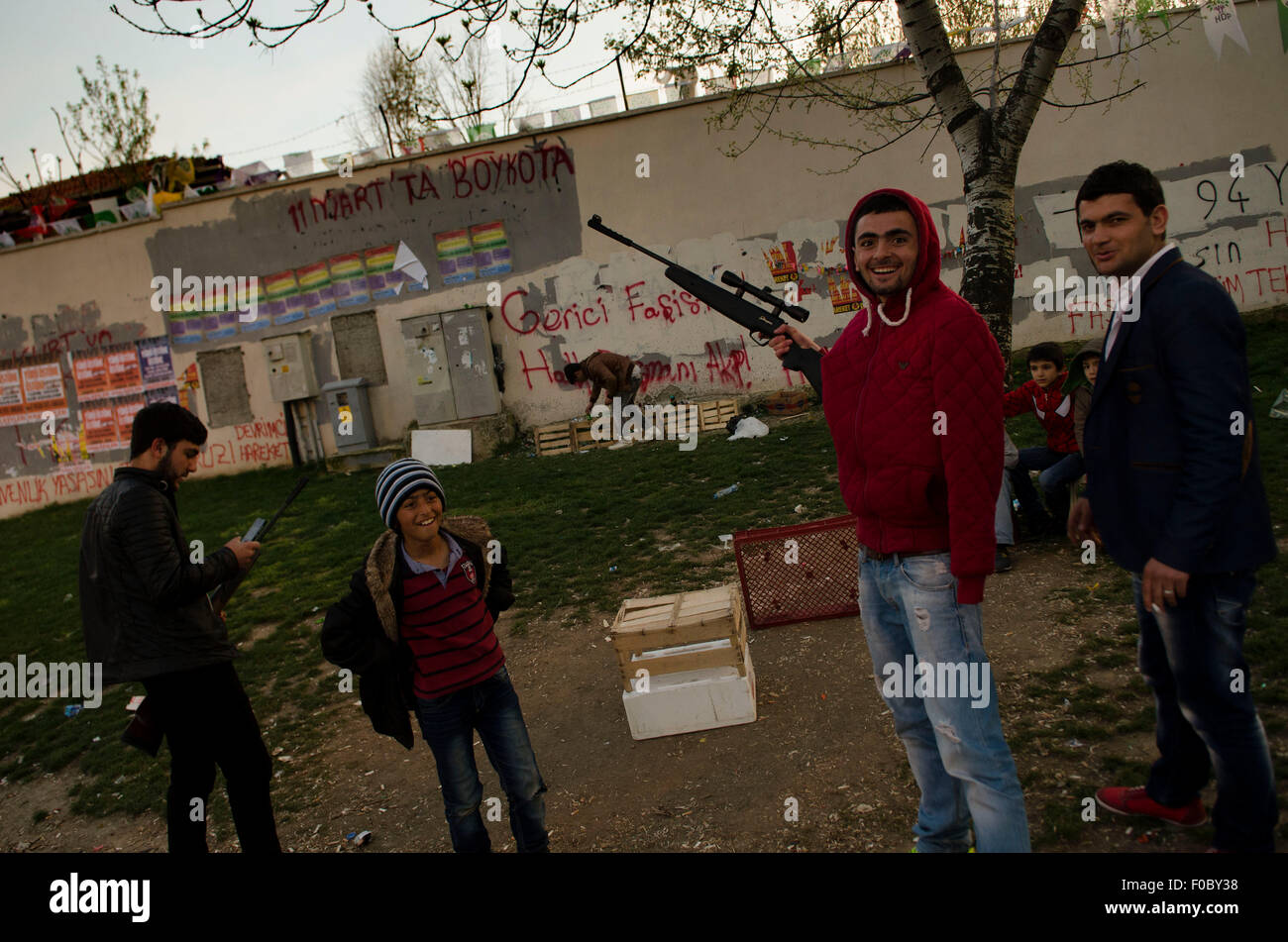 Shooting bottles in a park in Istanbul neighborhood of Okmaydani with walls covered in anti (government) AkP slogans Stock Photo
