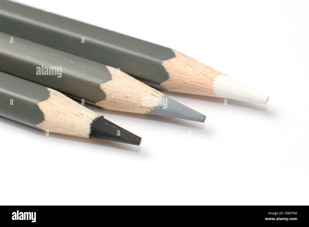 Three greyscale pencil crayons on a white background Stock Photo