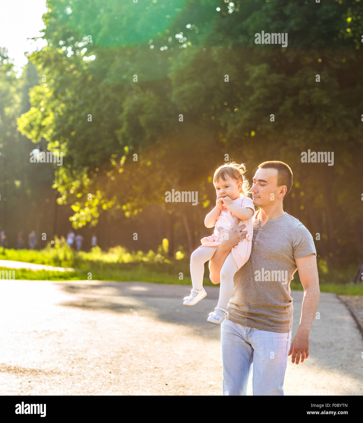 baby girl walking in a summer park with her father Stock Photo - Alamy