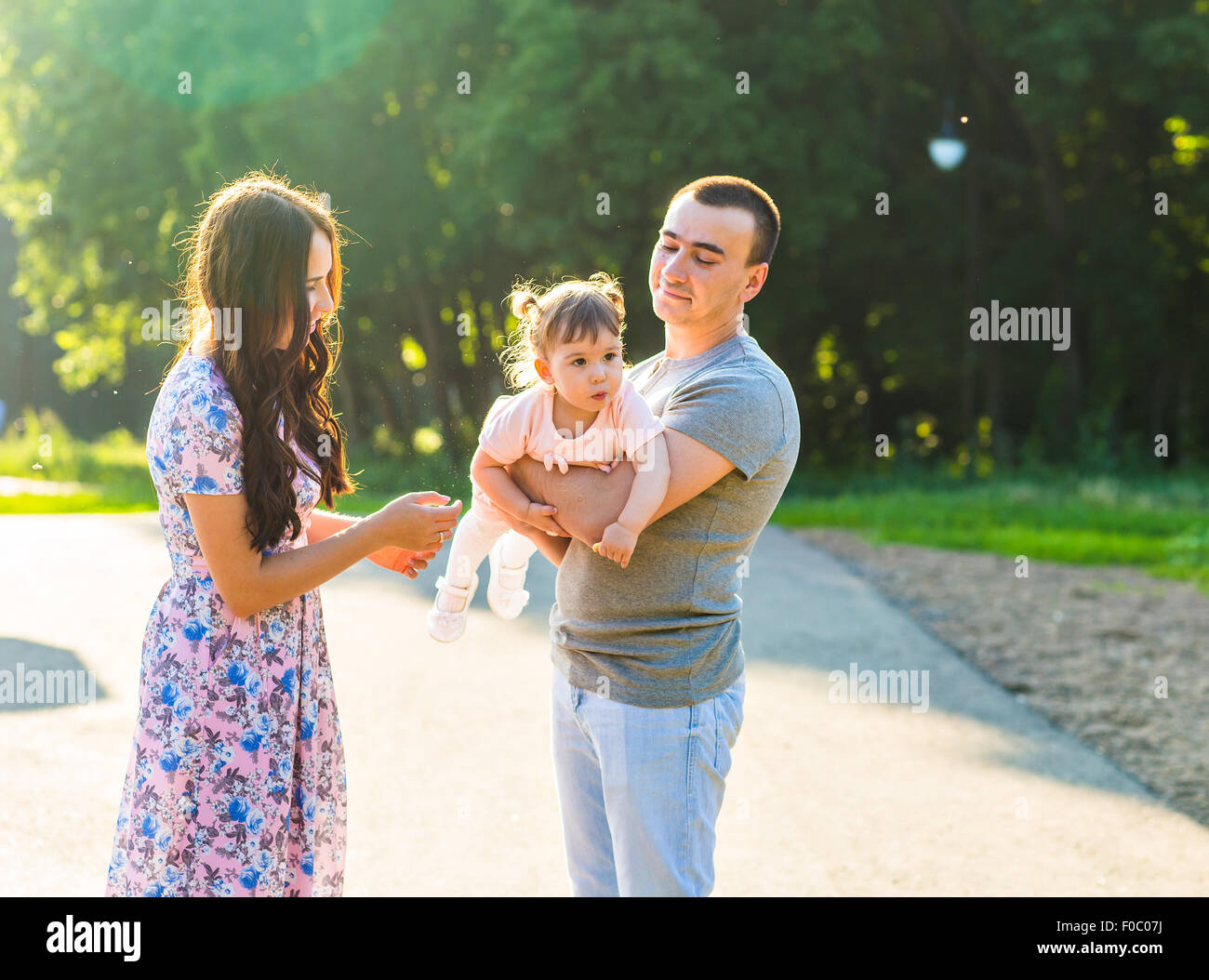 Happy Young Family Walking In The Park Stock Photo - Alamy