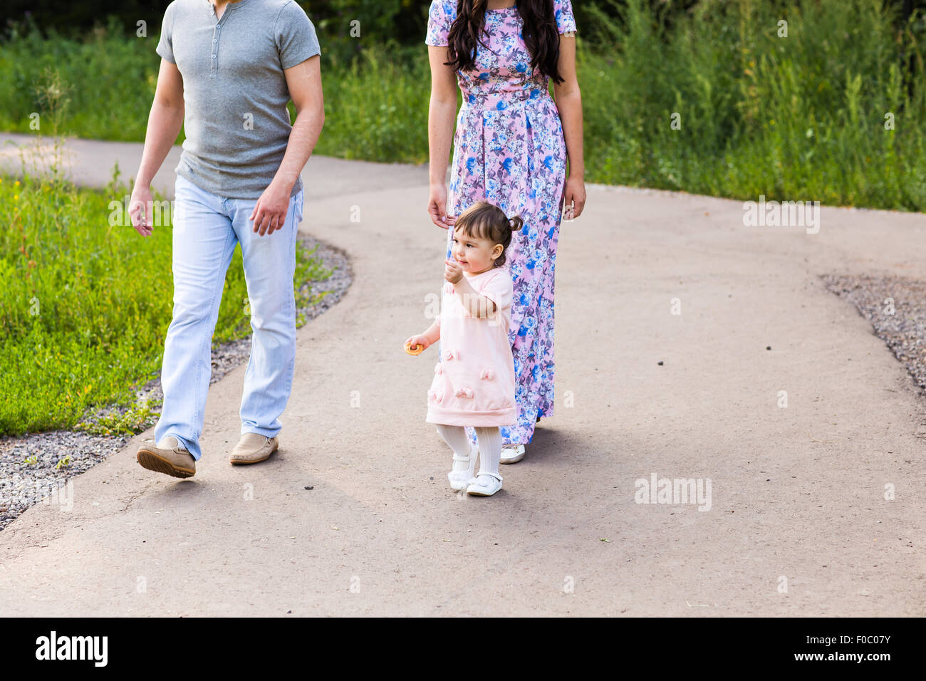 Happy Young Family Walking In The Park Stock Photo - Alamy