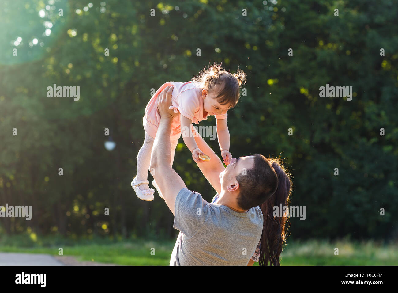 Happy Young Family Walking In The Park Stock Photo - Alamy