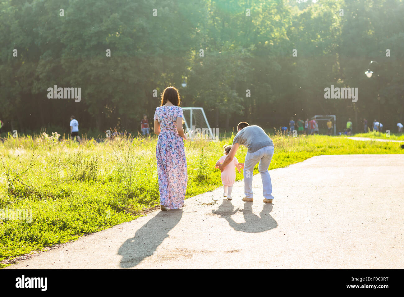Happy Young Family Walking In The Park Stock Photo - Alamy