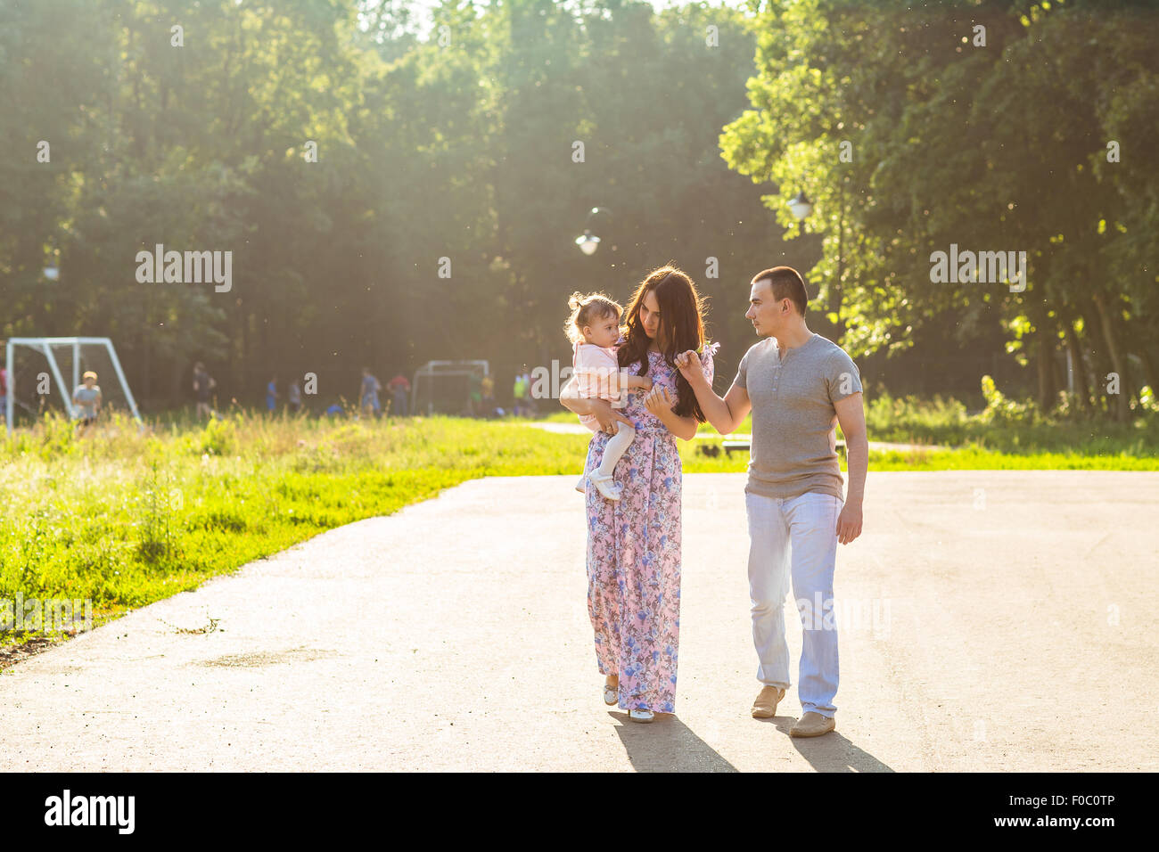 Happy Young Family Walking In The Park Stock Photo - Alamy
