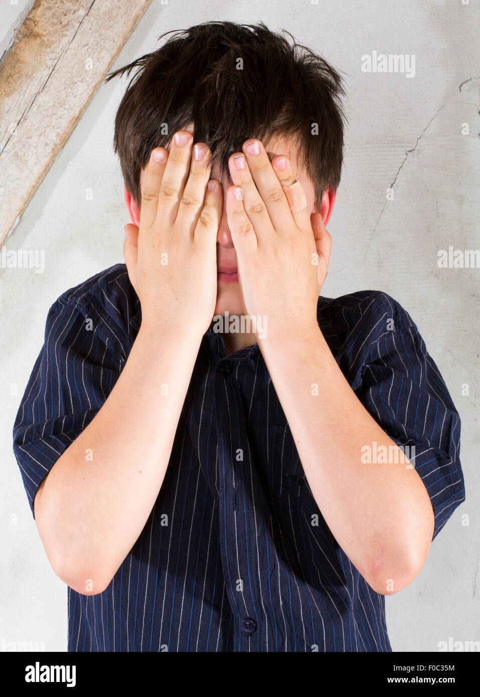 portrait of a young boy in a shirt covering his eyes Stock Photo - Alamy