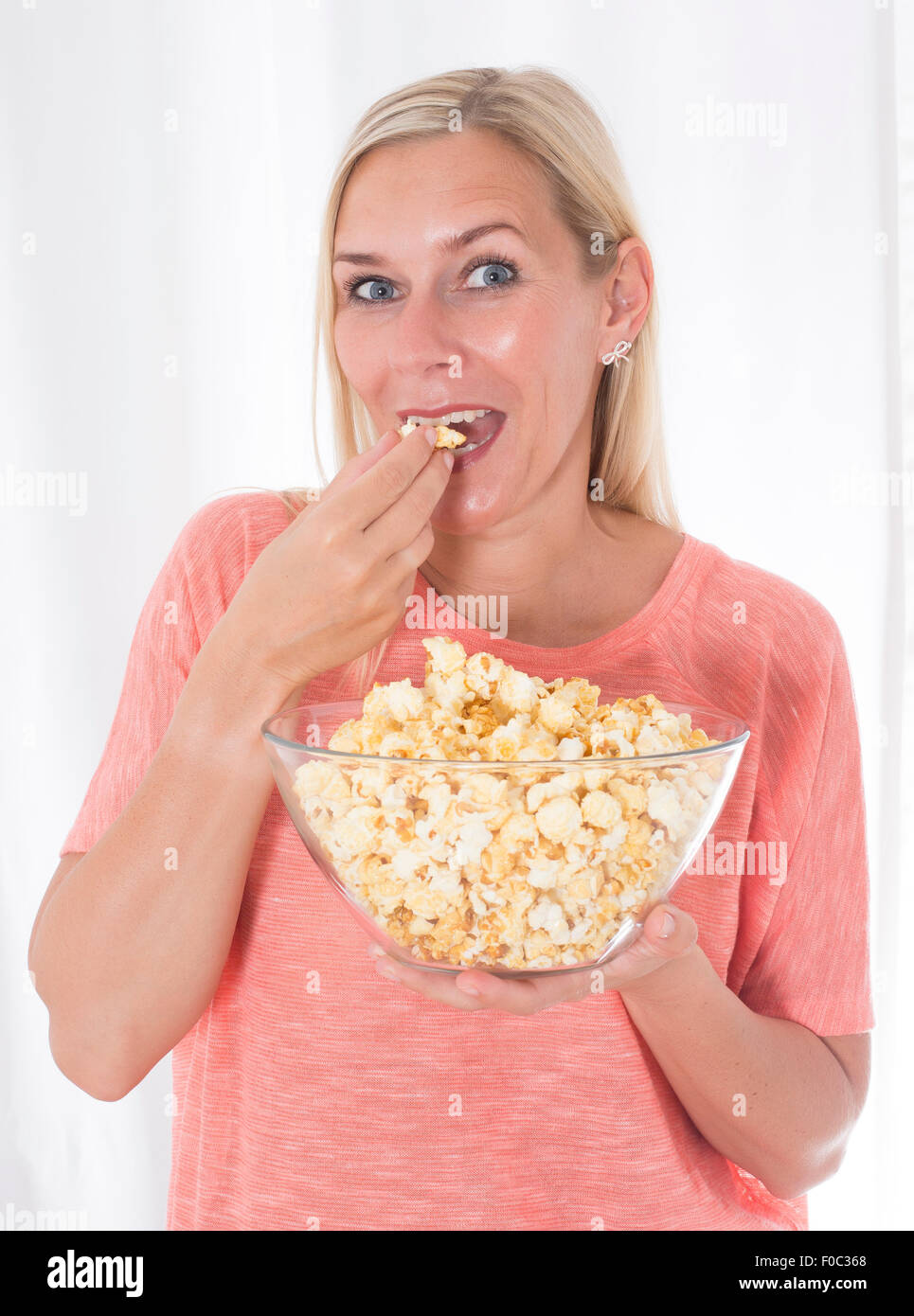 portrait of a blond woman eating popcorn Stock Photo Alamy