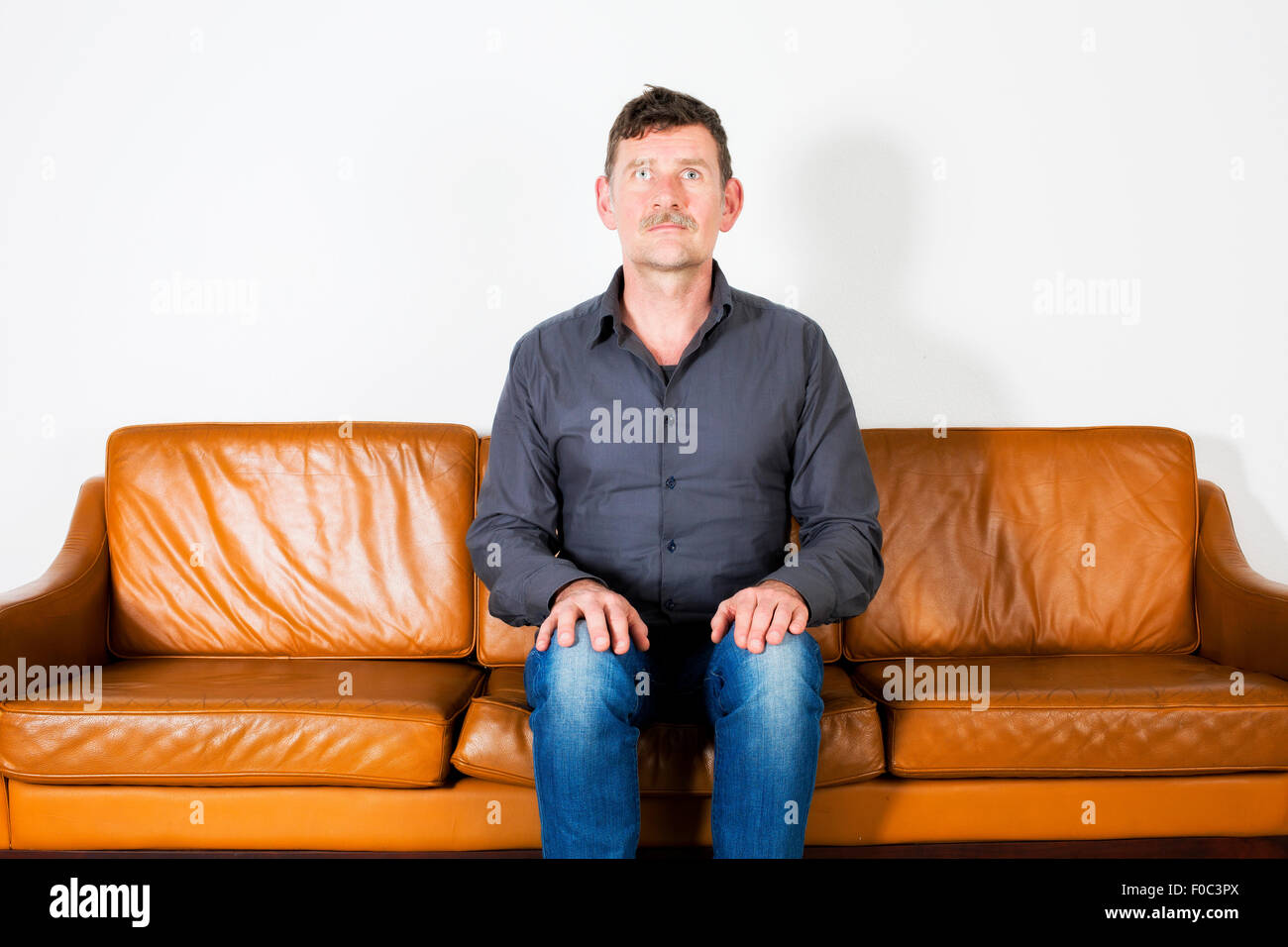 man sitting on couch and waiting Stock Photo Alamy