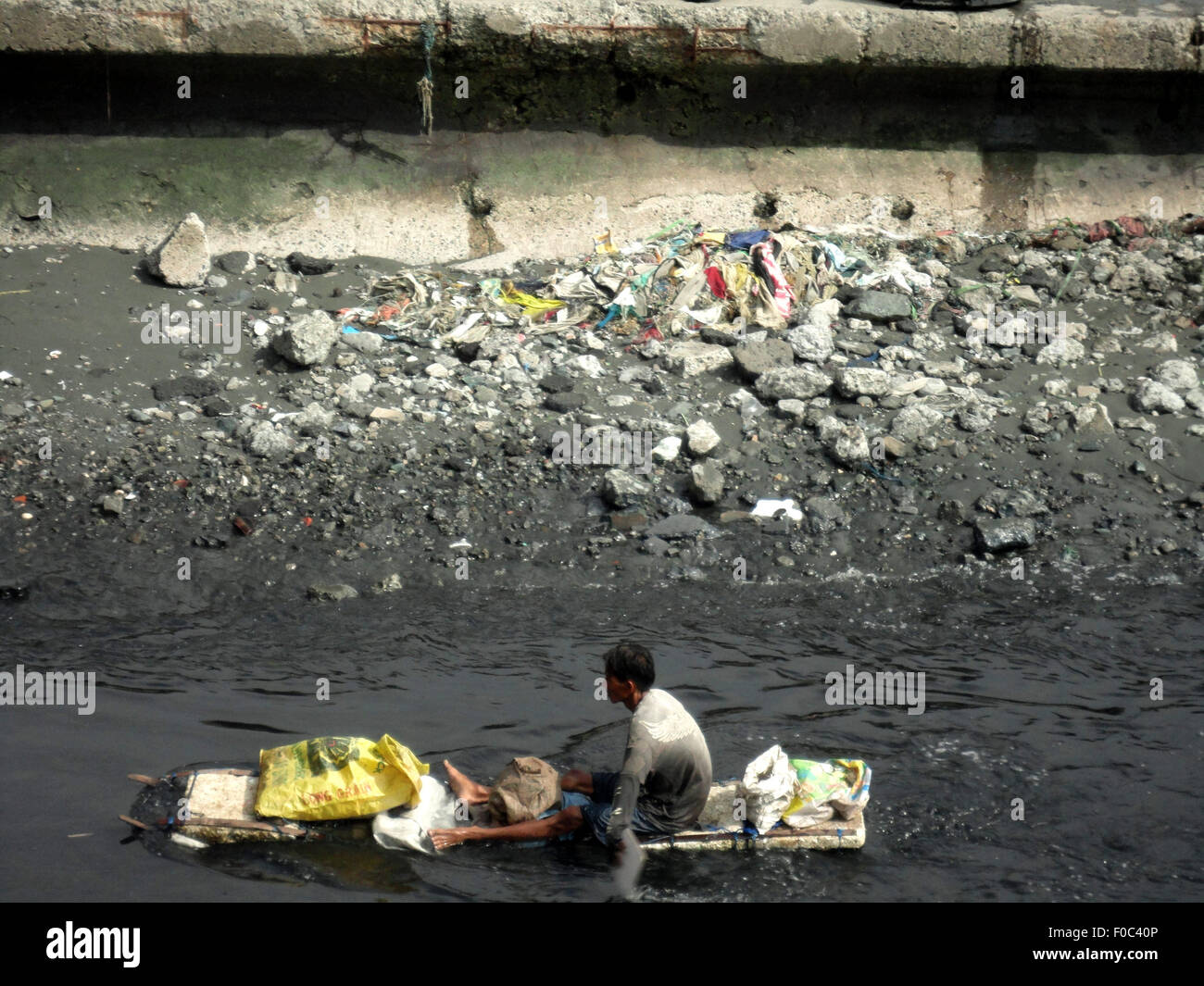 Navotas City, Philippines. 12th Aug, 2015. A Filipino paddles on his ...