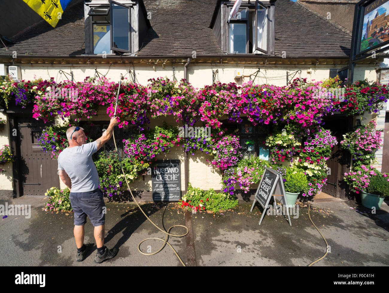 Landlord Bryn Masterman waters hanging baskets outside the Old Castle pub in Bridgnorth