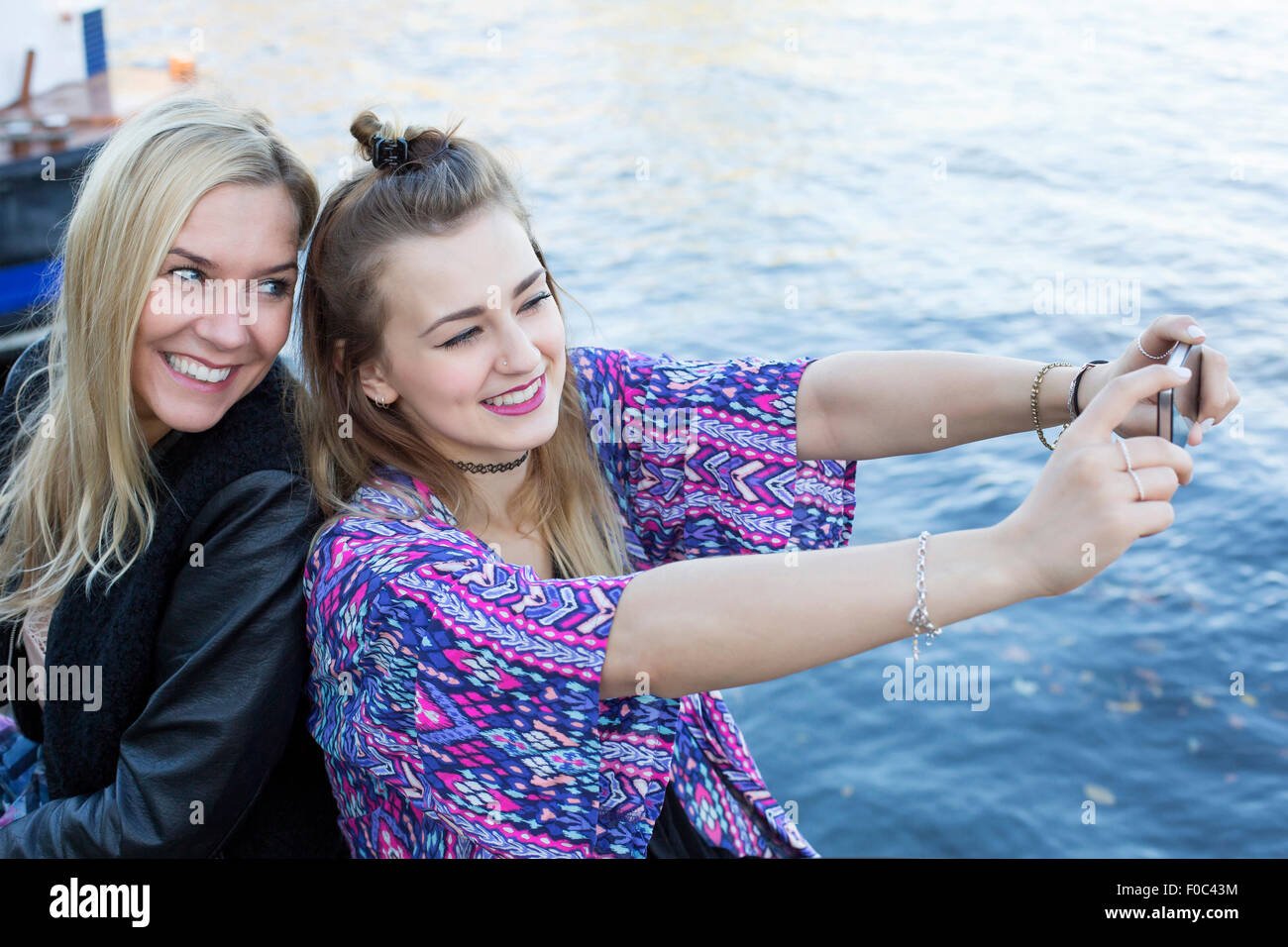 two women by the waterfront taking a selfie Stock Photo - Alamy