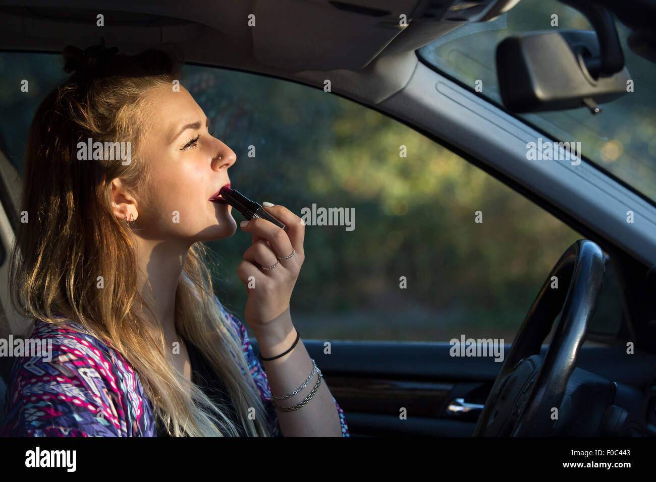 Frau im Auto mit Visier Schminkspiegel Make-up aufzulegen Stockfotografie -  Alamy