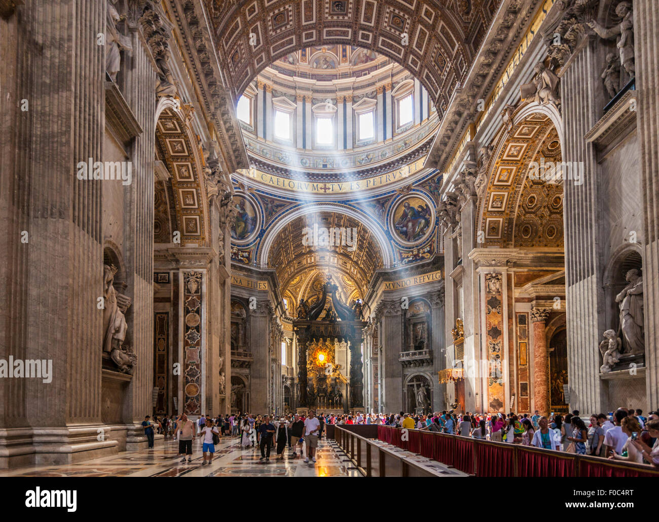 Tourists and visitors inside St Peters Basilica with light shafts coming through the dome roof  Interior Rome Italy EU Europe Stock Photo