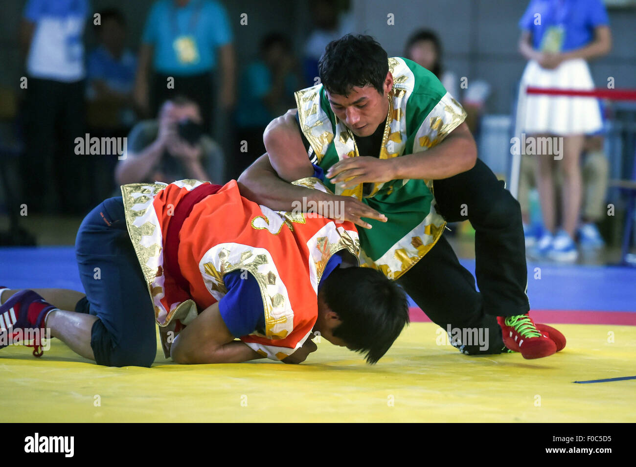 Ordos, China's Inner Mongolia Autonomous Region. 12th Aug, 2015. Athletes compete in a match of Uygurian-style wrestling during the 10th National Traditional Games of Ethnic Minorities of China in Ordos, north China's Inner Mongolia Autonomous Region, Aug. 12, 2015. In the event of wrestling of the ethnic minorities, athletes competed in 6 kinds of matches, namely the Tibetan-style wrestling, Mongolian-style wrestling, Korean-style wrestling, Hui-style wrestling, Yi-style wrestling and Uygurian-style wrestling. © Ou Dongqu/Xinhua/Alamy Live News Stock Photo