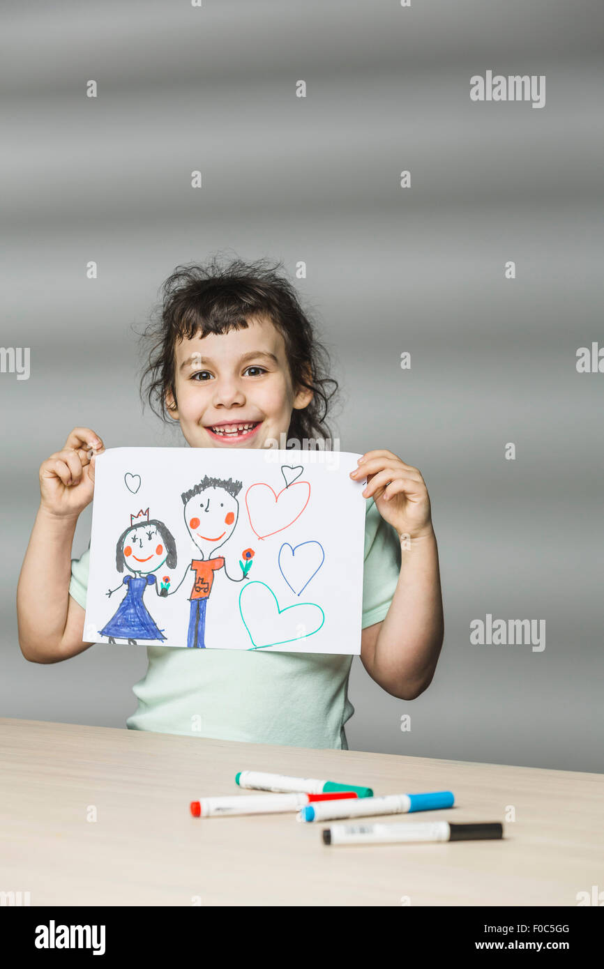 Portrait of smiling girl showing painting at home Stock Photo - Alamy