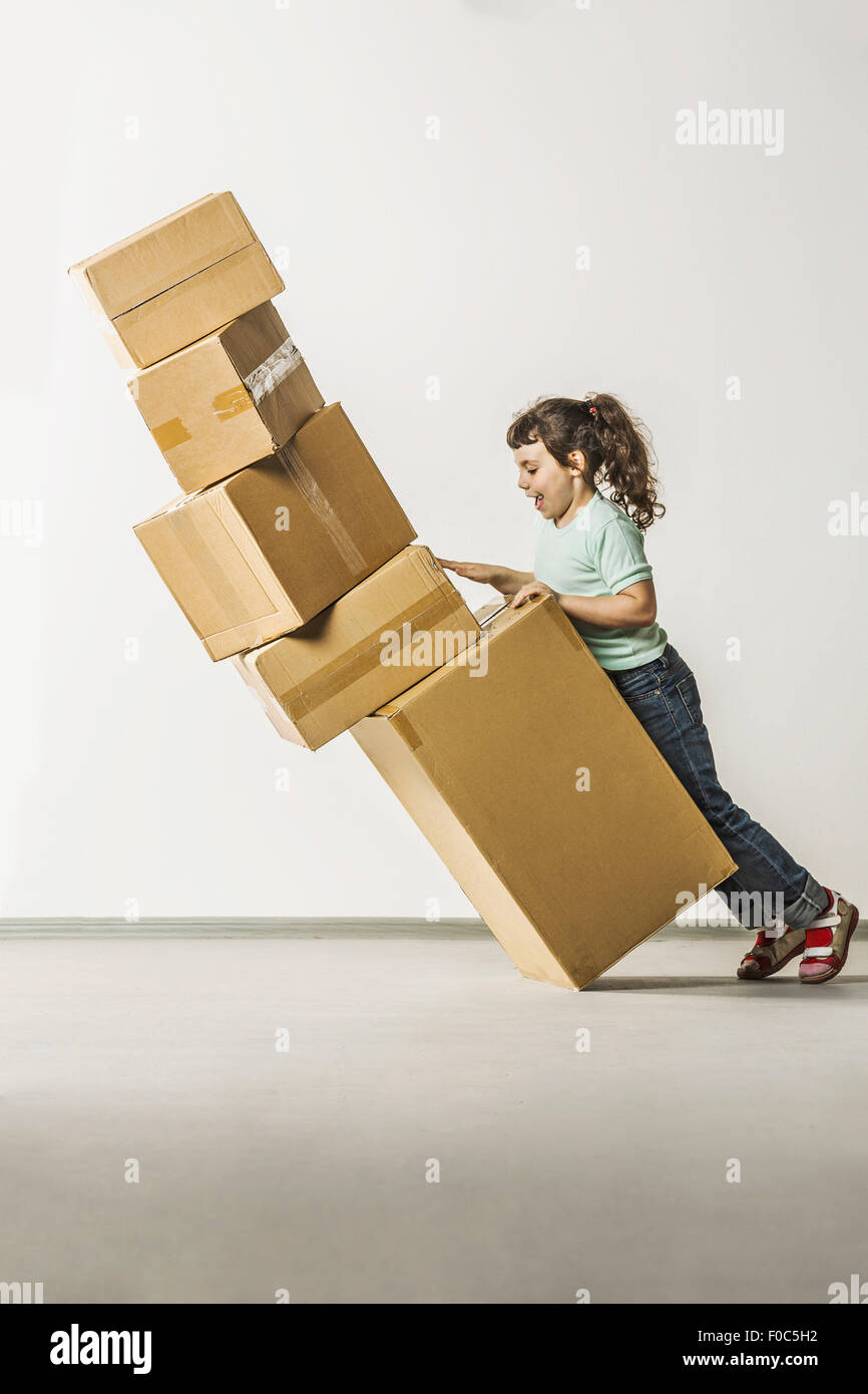 Full length side view of girl dropping boxes in house Stock Photo
