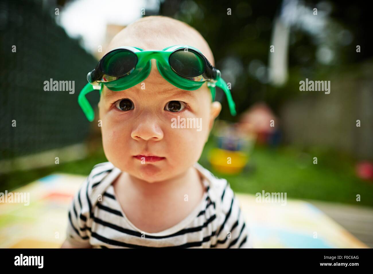 Close up portrait of baby boy looking at camera wearing swimming goggles Stock Photo