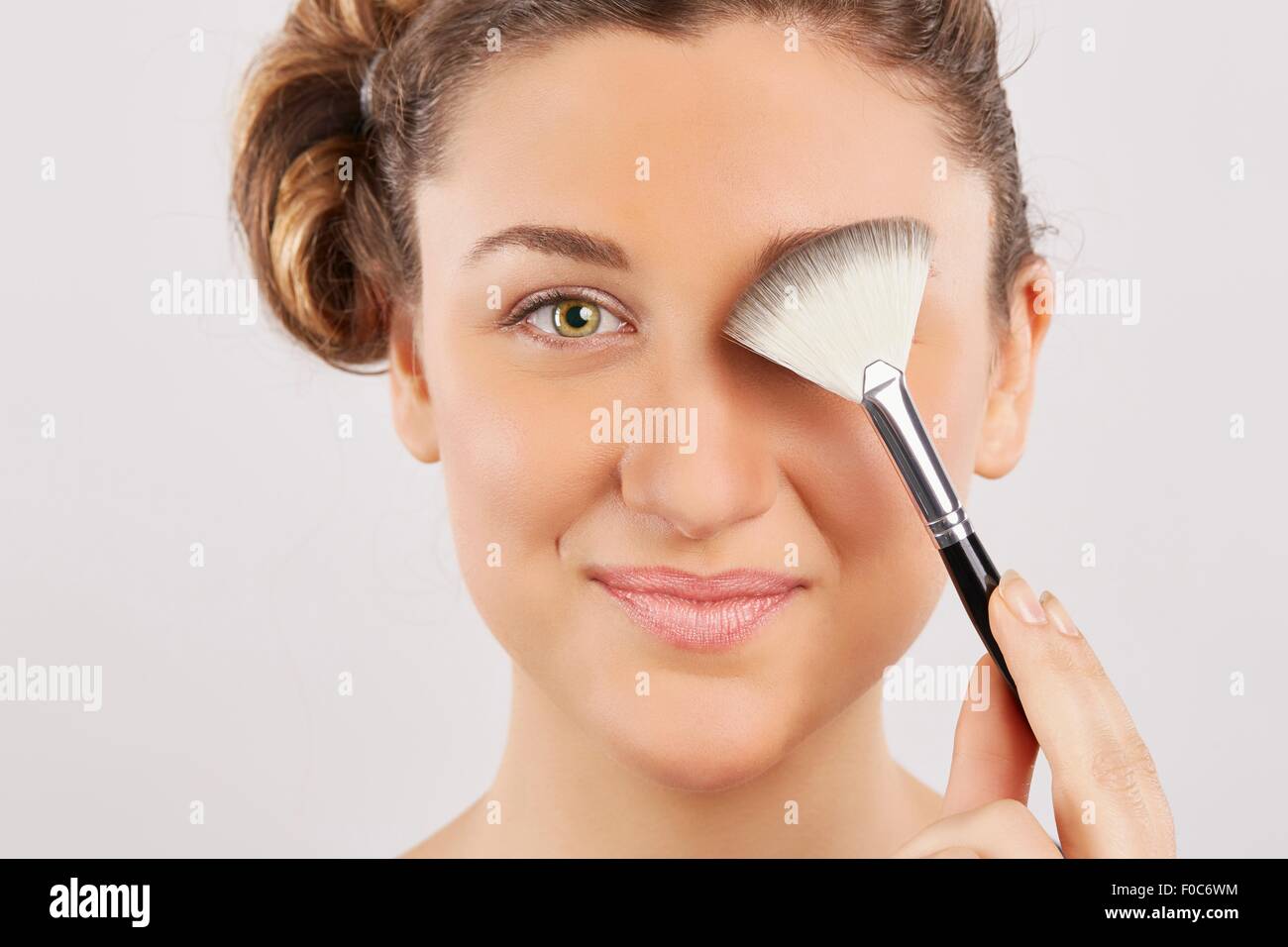 Young woman applying make-up Stock Photo