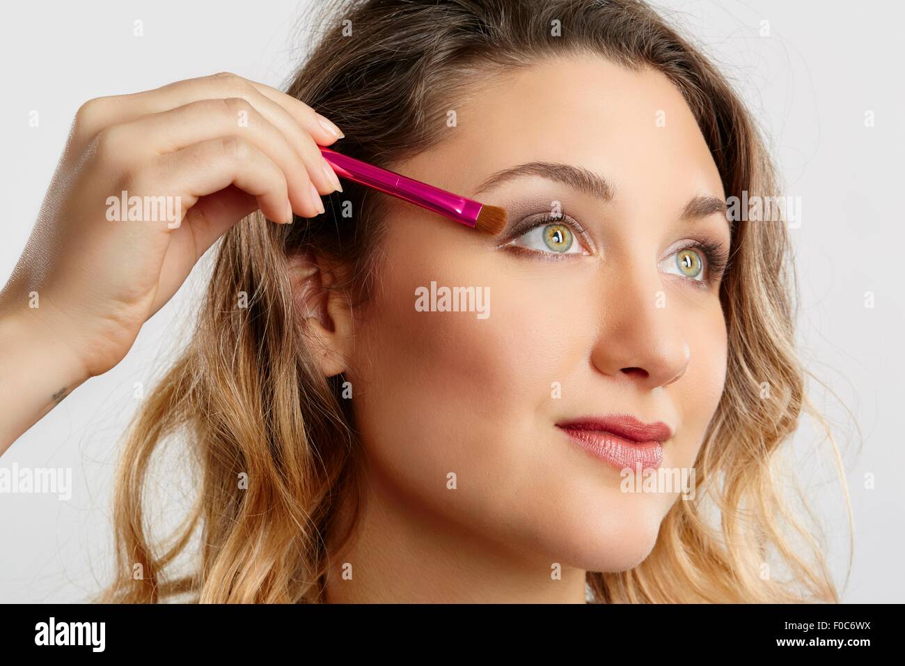 Young woman applying eyeshadow Stock Photo
