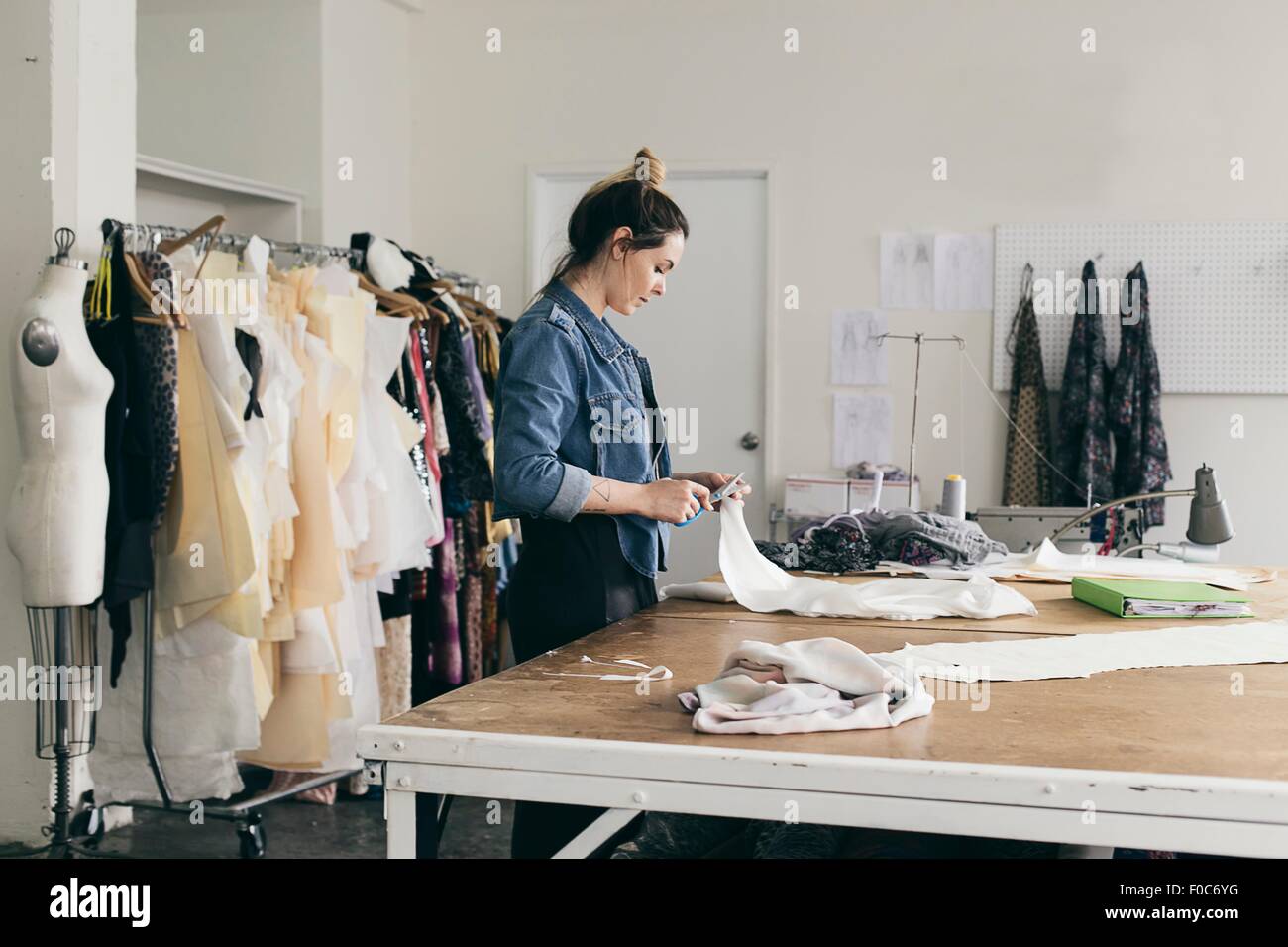 Young female seamstress cutting pattern in fashion studio Stock Photo