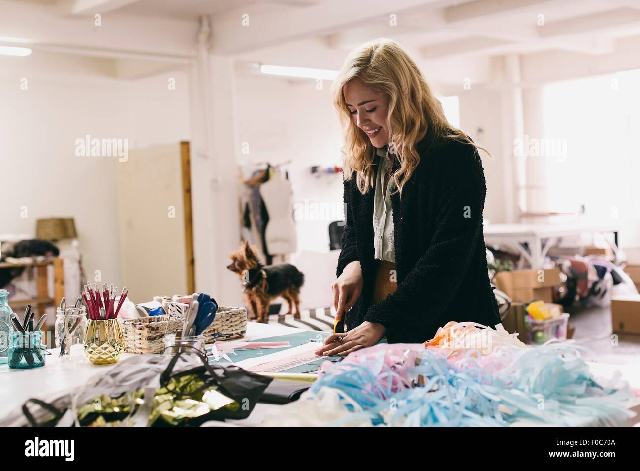 Female textile designer cutting textiles in design studio Stock Photo