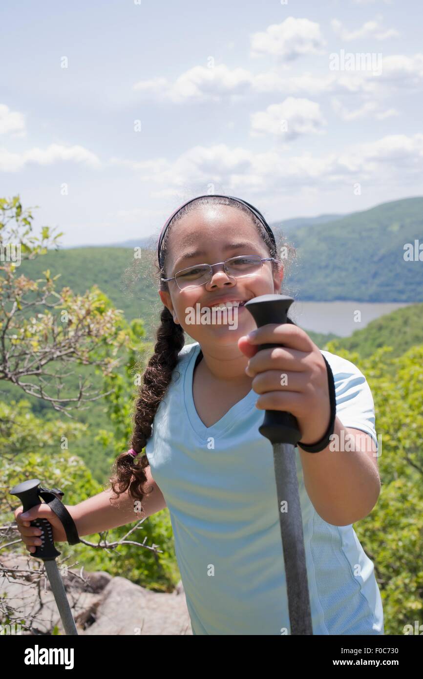 Young girl hiking up hilly landscape Stock Photo