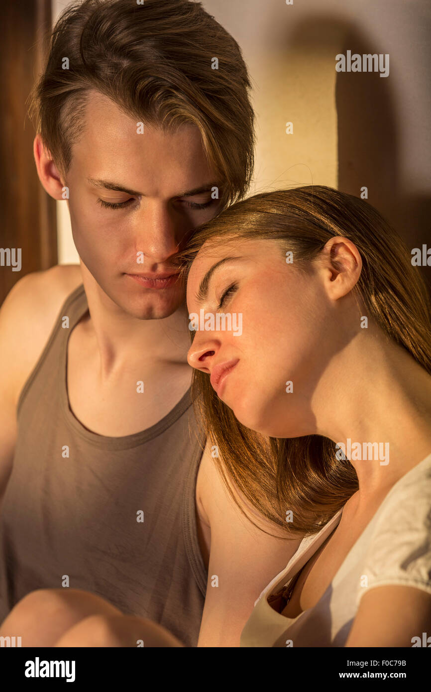 Young woman resting head on man's shoulder Stock Photo