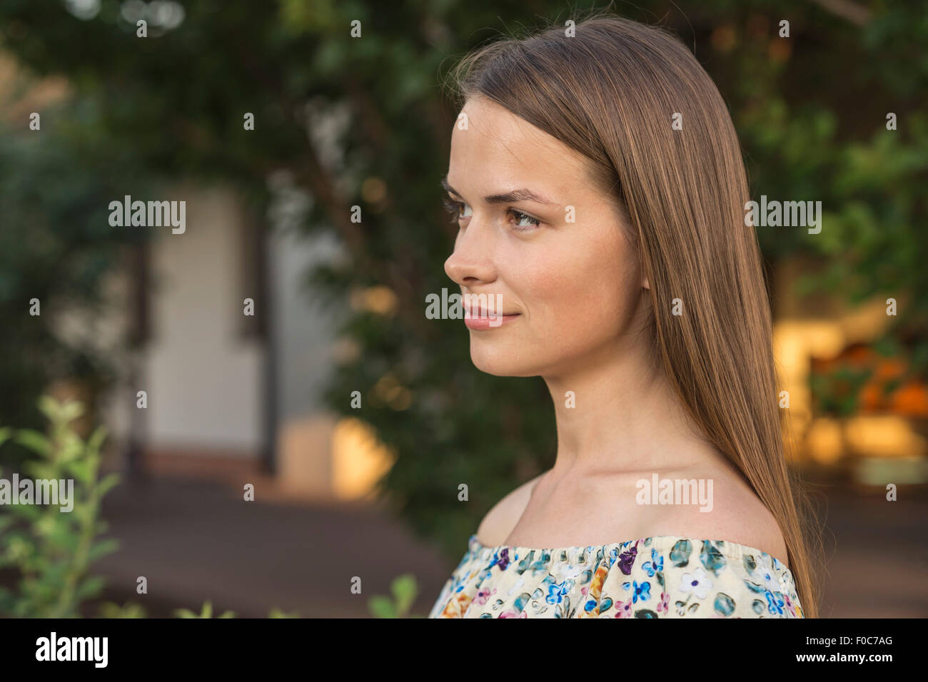 Side view of beautiful young woman looking away outdoors Stock Photo
