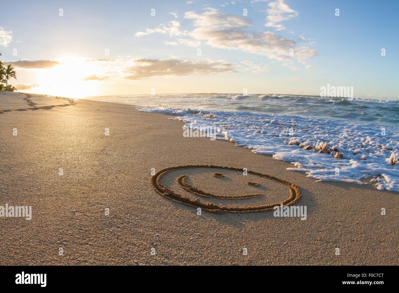 Smiley face, drawn in sand, sunset, Hawaii Stock Photo
