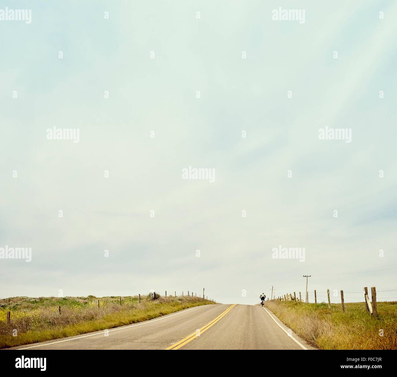 Distant view of cyclist on highway 1, Big Sur, California, USA Stock Photo