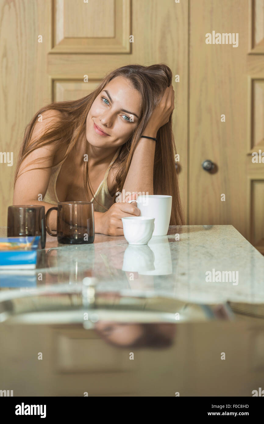 Portrait of beautiful young woman having coffee while sitting at table Stock Photo