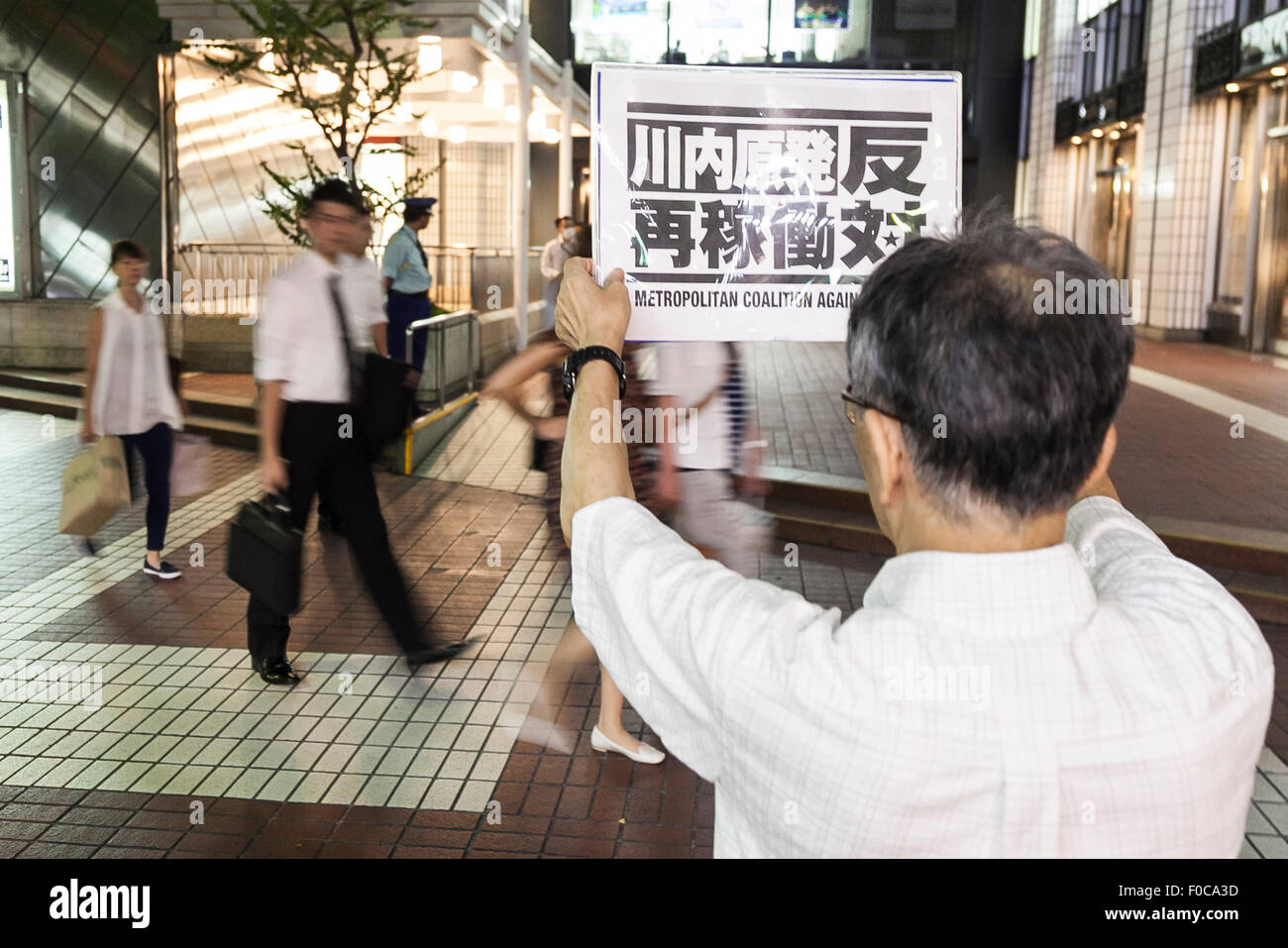 Tokyo, Japan. 12th Aug, 2015. A demonstrator holds a placard against the restart of Japan's Sendai nuclear power station outside the Kyushu Electric Power building in Tokyo, Japan on August 12, 2015. Many Japanese are against nuclear power and all reactors have been offline since the Fukushima nuclear disaster of 2011. The government and Kyushu Electric Power Co. announced the restart of the No. 1 reactor in the Sendai plant in Satsumasendai, Kagoshima. Credit:  Aflo Co. Ltd./Alamy Live News Stock Photo