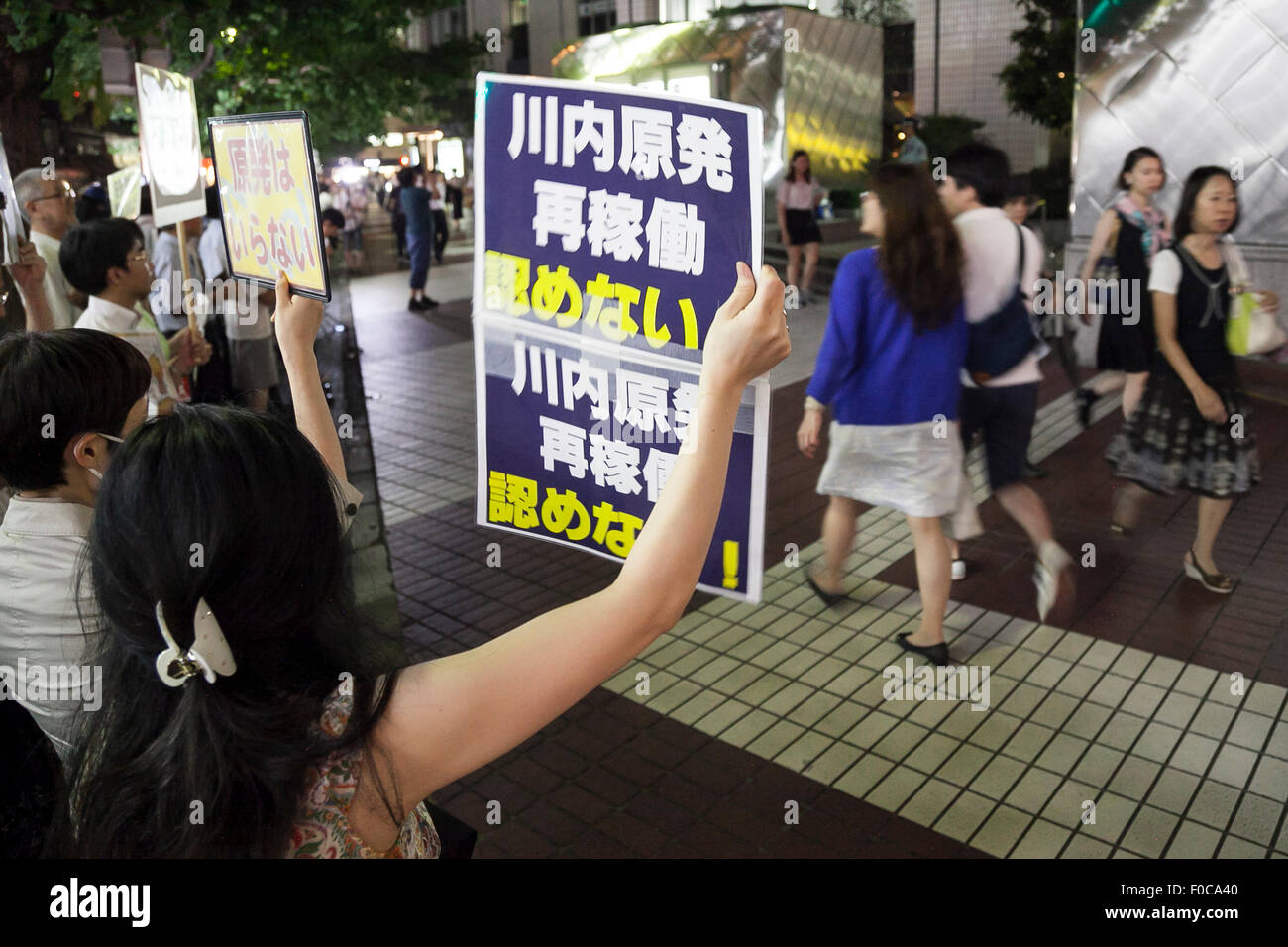 Tokyo, Japan. 12th Aug, 2015. Demonstrators hold placards against the restart of Japan's Sendai nuclear power station outside the Kyushu Electric Power building in Tokyo, Japan on August 12, 2015. Many Japanese are against nuclear power and all reactors have been offline since the Fukushima nuclear disaster of 2011. The government and Kyushu Electric Power Co. announced the restart of the No. 1 reactor in the Sendai plant in Satsumasendai, Kagoshima. Credit:  Aflo Co. Ltd./Alamy Live News Stock Photo