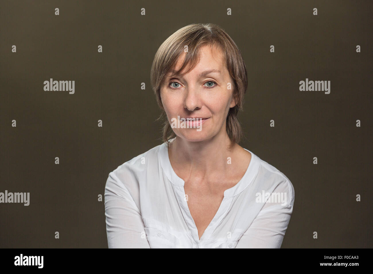 Portrait of confident mature woman over gray background Stock Photo