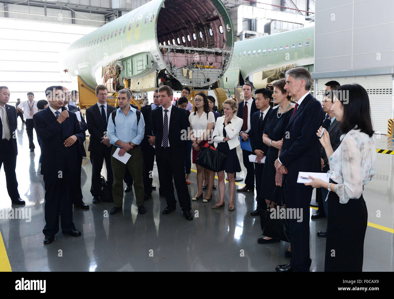 Tianjin, China. 12th Aug, 2015. A staff member gives an introduction to British Foreign Secretary Philip Hammond at the Airbus factory in Tianjin, north China, Aug. 12, 2015. Tianjin is the first stop of Philip Hammond's visit in China. Credit:  Zhang Chenlin/Xinhua/Alamy Live News Stock Photo