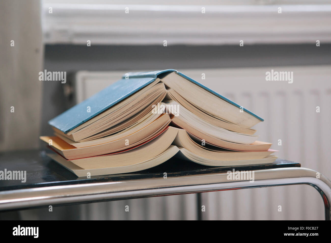 Close-up of stacked open books on table Stock Photo