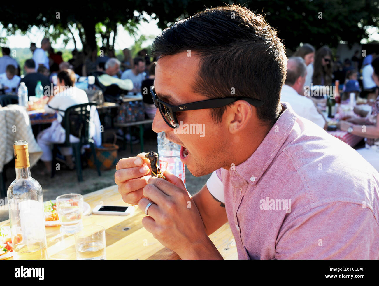 Young man eating freshly cooked snails or l'escargots at the Picnic