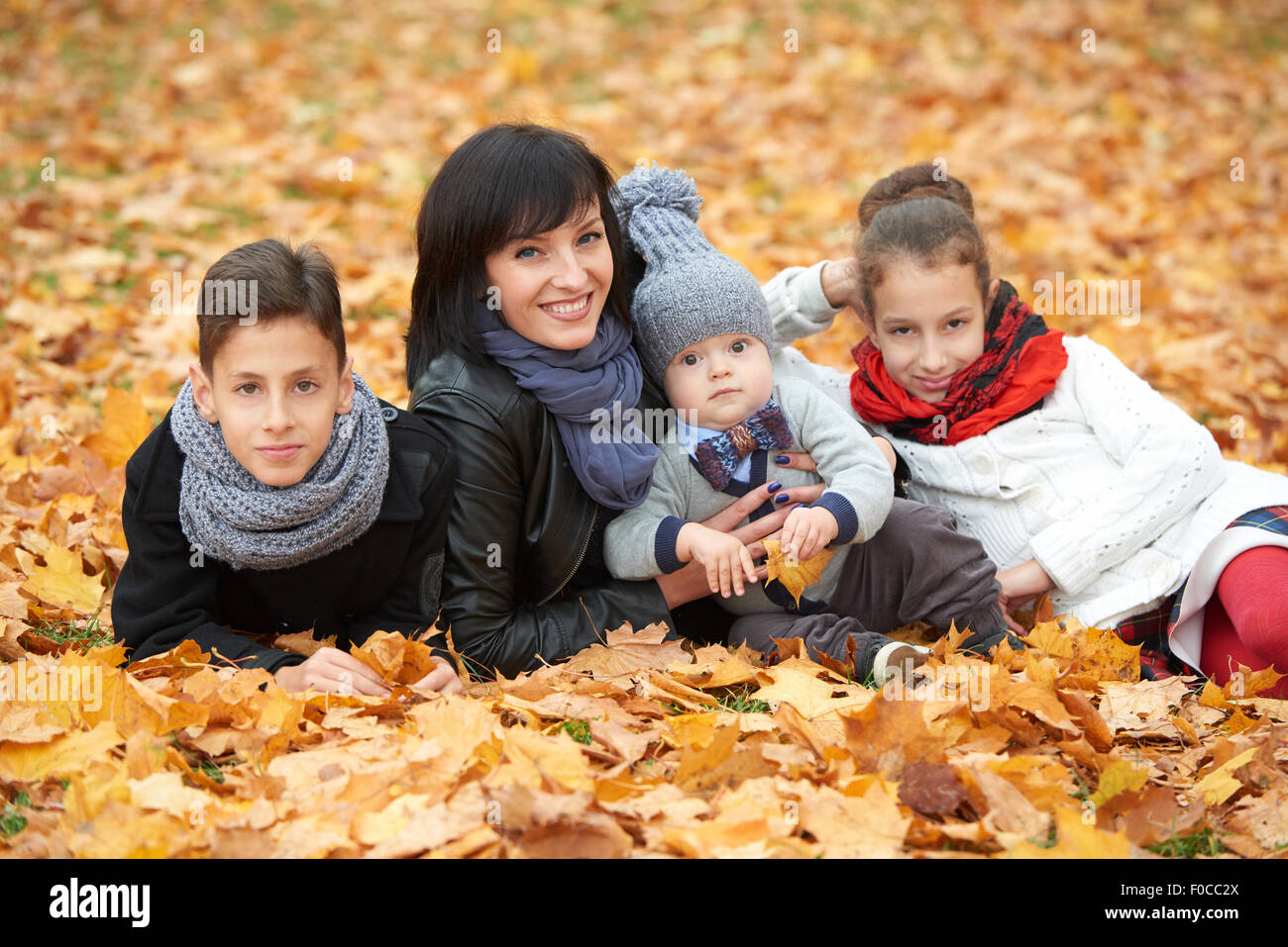 family in autumn park on yellow leaves Stock Photo